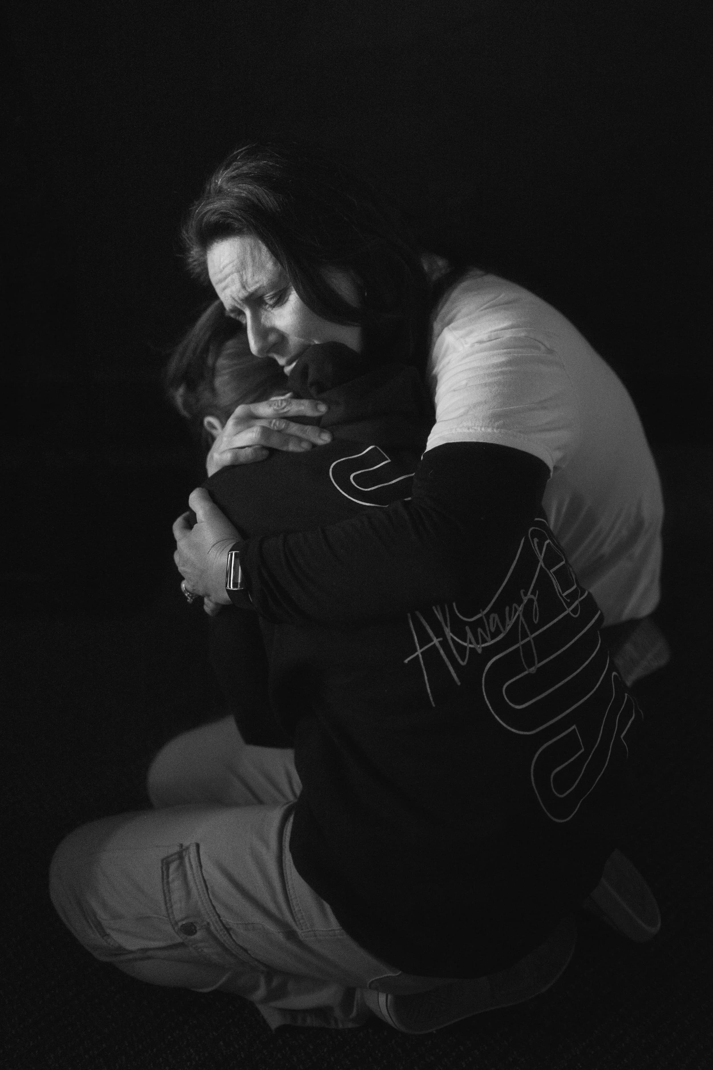 Two people embracing in prayer
