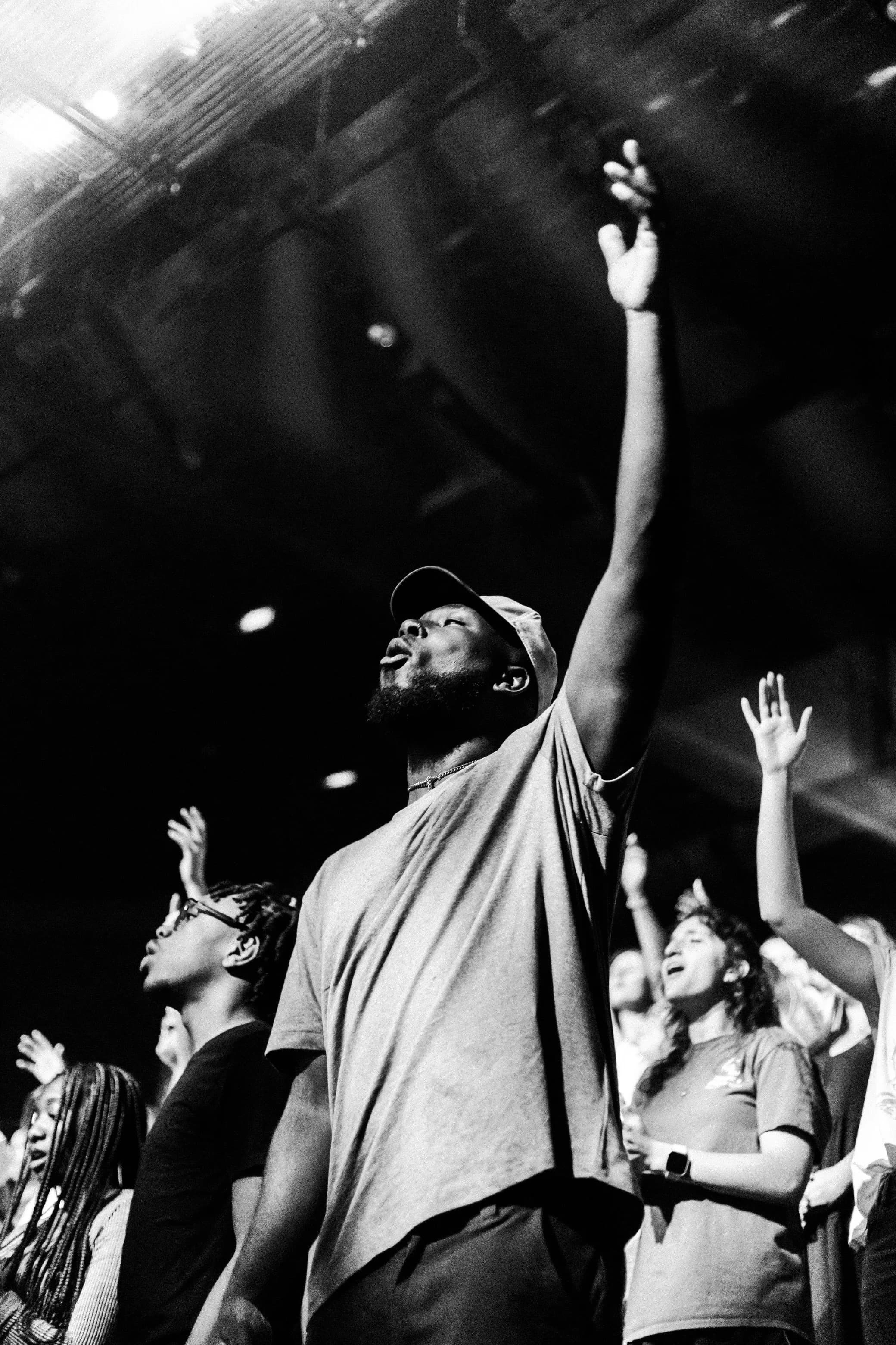 Hands raised in worship under the stage lights